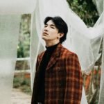 Portrait of a fashionable man in a stylish plaid coat posing outdoors in Jawa Barat, Indonesia.